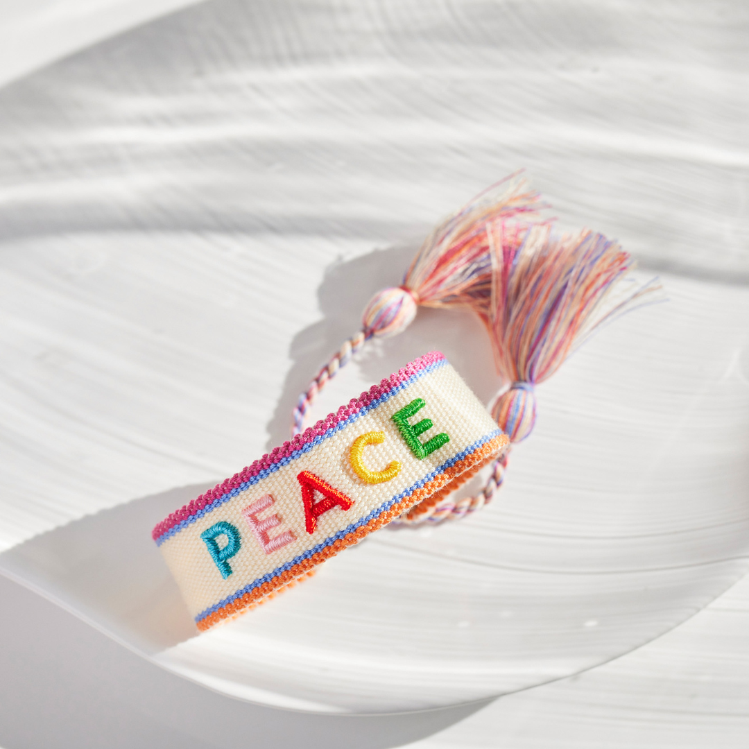 "PEACE" Statement Armband in cremeweiß/bunt mit Quasten im Hippie Style von Josemma - kosmetikkaufen.shop